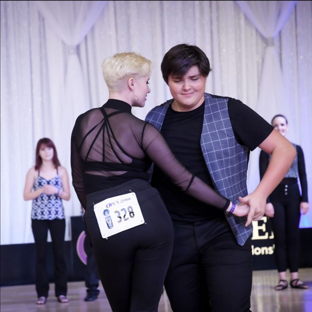 Photo of two dancers competing in a West Coast Swing dance competition.